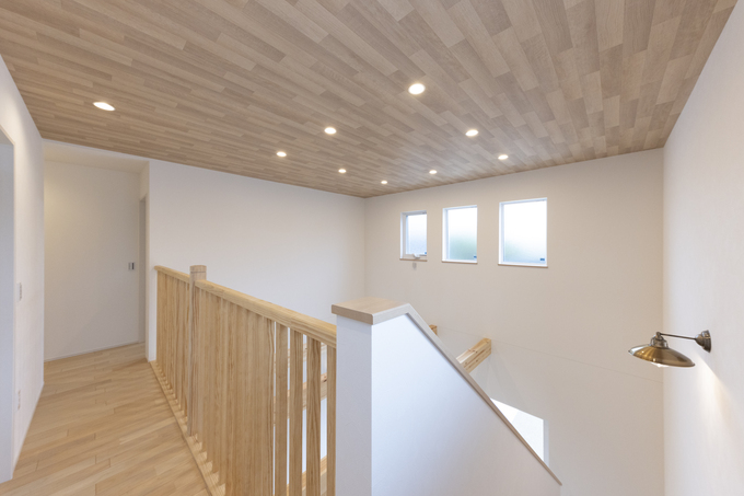 明るい木目調の天井と壁が印象的なモダンな廊下空間。シンプルなデザインでありながら優れた照明計画により、快適さと実用性を兼ね備えている。