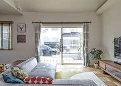 リビングから眺めるテラス。南側にはテラス窓があり、ウッドデッキと連続。光と風を取り込んで室内に開放感をもたらしている