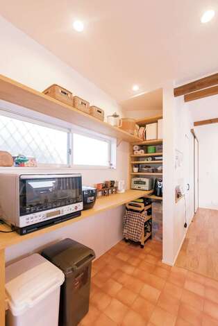 ものを増やさないために、収納はあえて少なめに。キッチンの背面は造作のオープンシェルフを。お客さまからは見えない部分に、食材などのストックができる収納棚を設けた