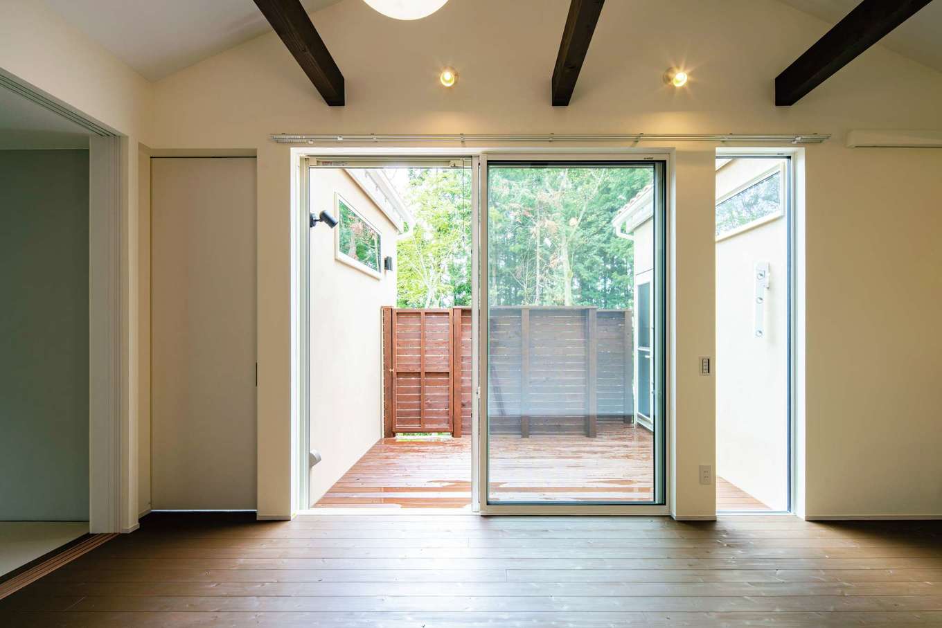 Dairyu Home（シンプルノート御殿場・小山・裾野）【輸入住宅、自然素材、夫婦で暮らす】ウッドデッキを効果的に利用した窓の配置が、室内に十分な自然光を取り込む。室内を明るく保ち、通風の良さも叶えた設計に。フロア続きなので、アウトドアリビングとしても活躍。ウッドデッキから直接庭へ降りられる階段も設置。フェンスで囲われたプライベートな空間