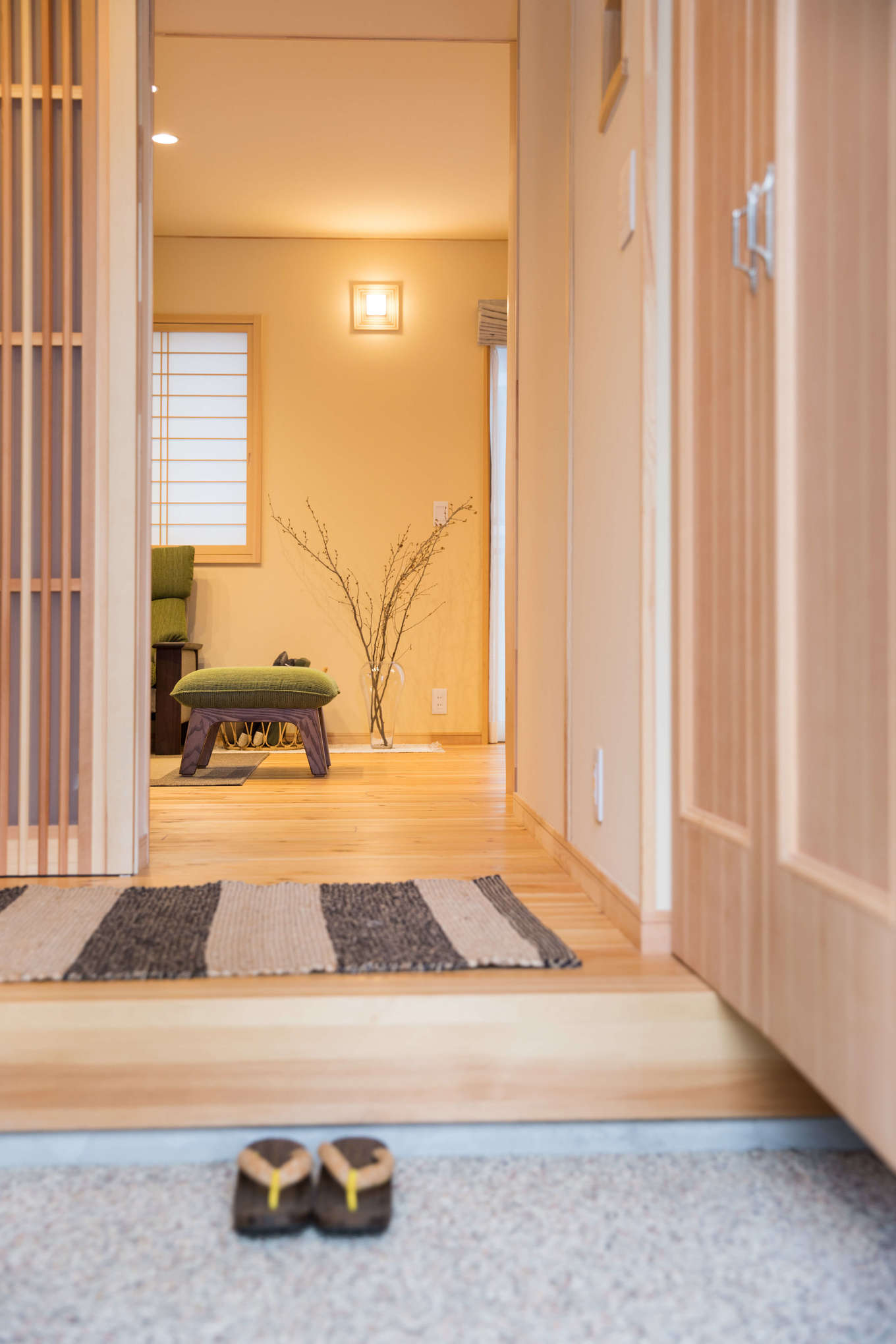 瀧口建設【デザイン住宅、子育て、和風】玄関の戸を開けると、洗い出しの土間が迎えてくれる。奥様が選んだお香とヒノキの匂いが混ざり合い、心がホッと落ち着いていくのがわかる。床、壁、建具類はすべて、無垢材を使った人気の住宅ブランド「夢ハウス」仕様。木の優しい色合いが美しい