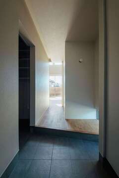 入った瞬間、視線が遠くまで抜けていくエントランス。まっすぐ進むとリビングへ、左手に進むとご主人のウエットスーツや仕事着を収納するファミリークローゼット→洗面脱衣室→浴室→キッチンへとつながる