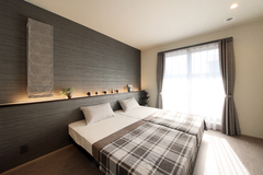 モダンなデザインの寝室。シンプルで洗練されたインテリアにより、落ち着いた雰囲気を感じさせる。採光が十分に取り入れられた快適な空間である。