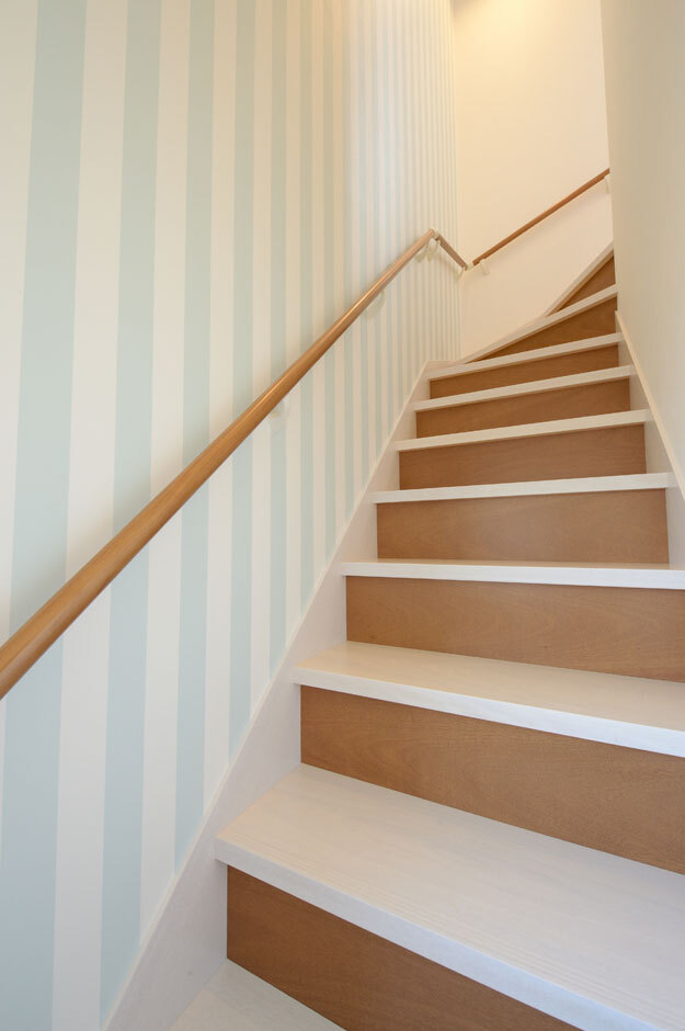 1階の間取り、素材、インテリアはご主人の要望通りにコーディネートされ、2階は奥さまの好みを反映したそう。階段の壁にはポップなデザインのクロスを採用し、おしゃれな店舗のような雰囲気を演出