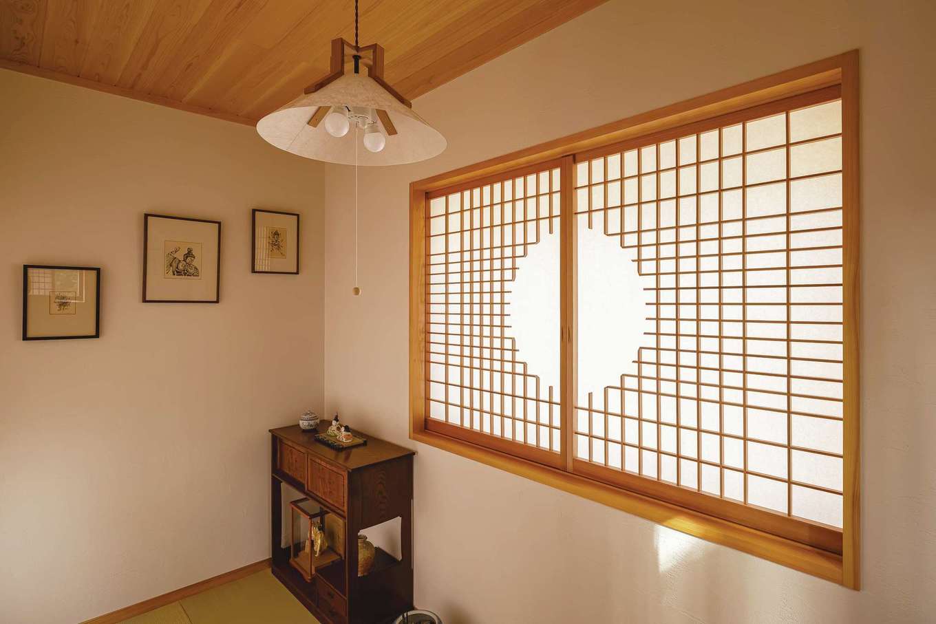 藤田工務店【自然素材、間取り、インテリア】障子の桟は丸窓をデザインして造作したオリジナル。職人の技術の高さが伺える。壁には奥さまが制作した銅板がが飾られている