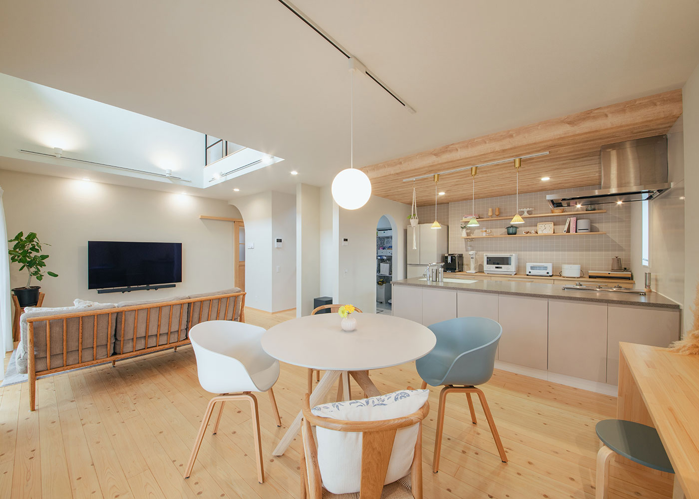 フジモクの家（富士木材）【趣味、自然素材、間取り】LDKは全体で22畳を越える広さをもち、L字型の構成と天井高の違いから、役割が穏やかに分けられた印象に。ダイニングテーブルは空間にやわらかくフィットする円卓を採用した