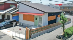 モダンでシンプルな外観が魅力の一戸建て。木材と金属が調和し、シックな印象を与えている。