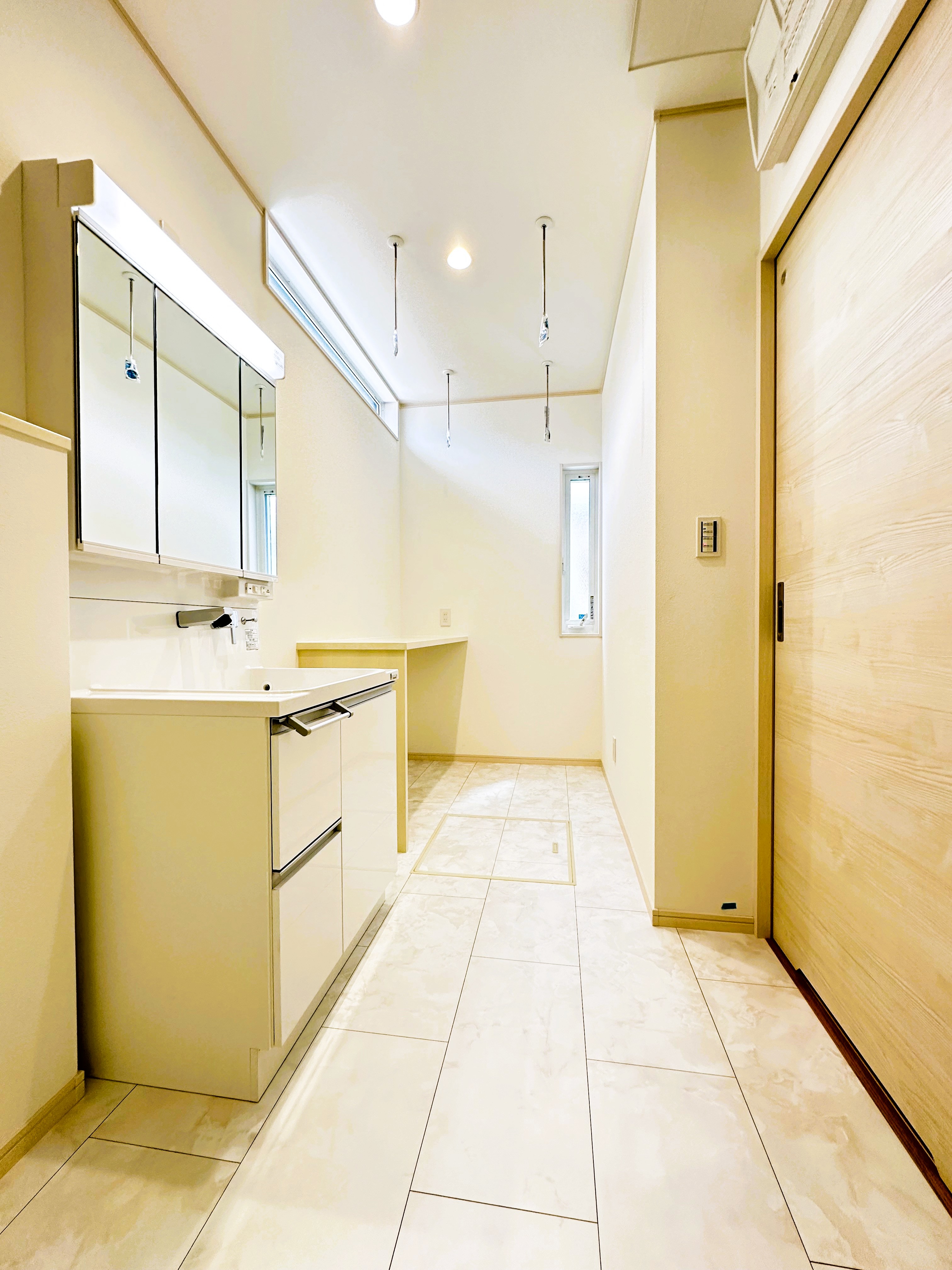 イシカワ 岐阜支店｜明るく清潔感のある洗面脱衣室。洗濯スペースも兼ねた広々した設計で、その場で干して、たたんでしまえる。ムダなく快適に使える空間が広がっている。