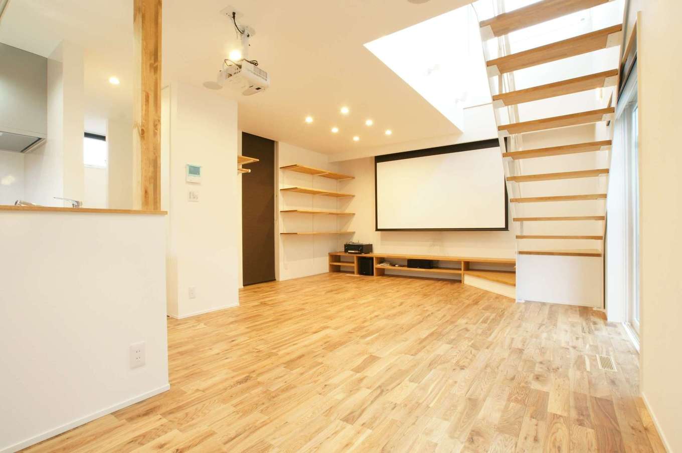 RIKYU 一級建築士事務所【デザイン住宅、間取り、インテリア】外からは想像もつかない23.7畳の大空間リビング。夫婦共通の趣味である映画を大画面、大音量で楽しむために100インチのホームシアター設備を導入した