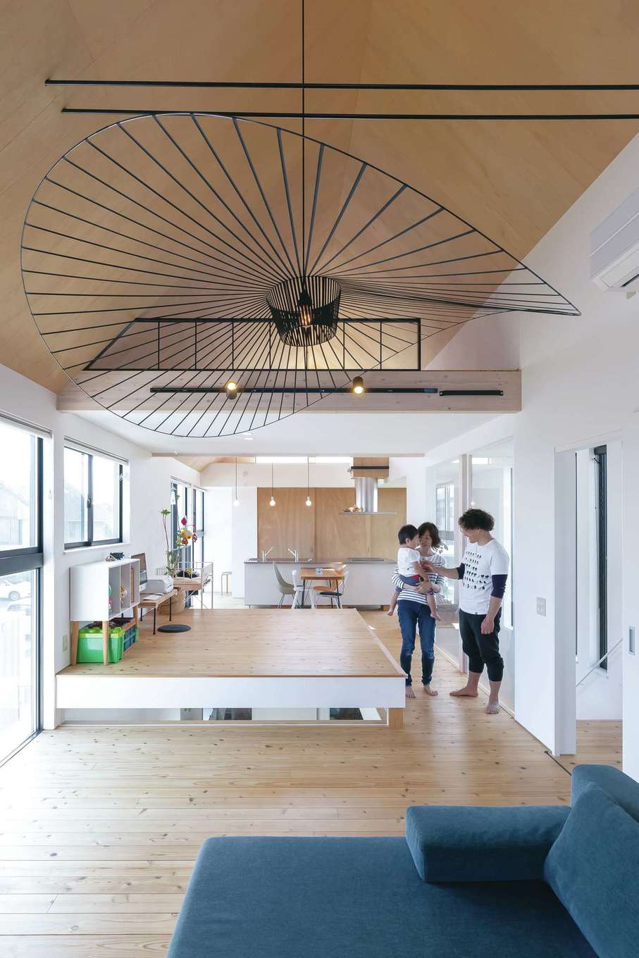 MABUCHI【デザイン住宅、建築家、インテリア】強烈なインパクトがある直径2mのペンダントライトは、新婚旅行で行ったフィンランドの雑貨店で見たものを直輸入。ハンス・J・ウェグナーのロッキングチェア、アルネ・ヤコブセンのドロップチェアなど、ご主人が買い集めた北欧家具が空間のデザイン性をより高める。やさしい肌触りの床は無垢の杉板、シンプルな質感が美しい天井はラワン材。約30畳の大空間に、やわらかな光があふれ心地いい風がそよぐ