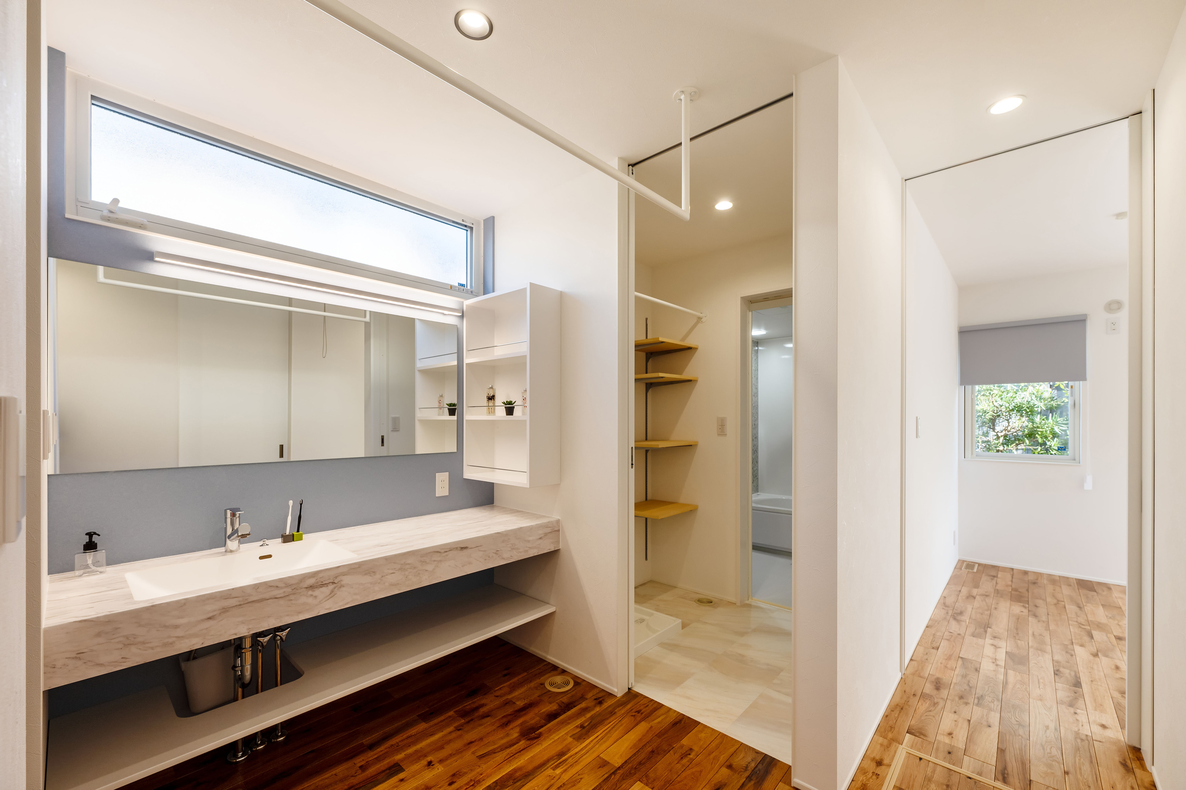 ハウスプラン（R＋house沼津・富士）【間取り、建築家、平屋】洗面台は土間収納と浴室の間にレイアウト。「将来、子どもがスポーツをやってくれたら」との思いから、帰宅してすぐ手洗いができ、そのまま浴室に直行できるようにした