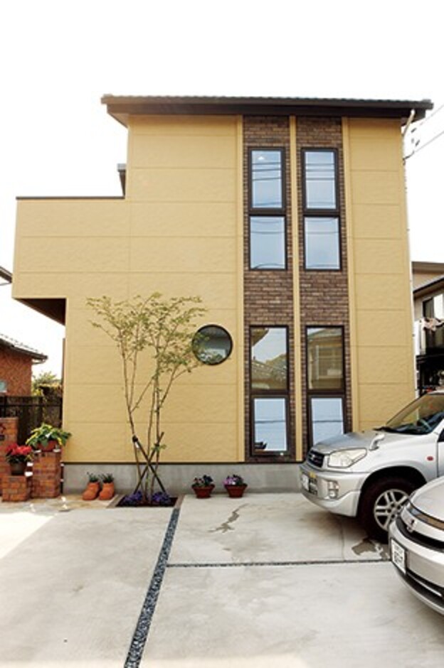 レンガタイルがアクセントになる駐車場側の壁には大きな窓を配置した