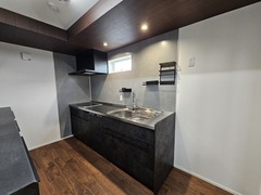 モダンなデザインのキッチン。黒を基調としたシックなカウンターが印象的で、使いやすさと美しさを兼ね備えている。