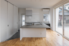 オープンキッチンのデザインで、広々とした調理スペースを提供。白とグレーのモノトーンカラーでシンプルかつスタイリッシュな雰囲気