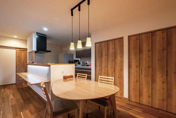 周遊動線、横並びのダイニング、機能的かつたっぷりの収納が家事効率を高める。宿題用のカウンターには、手元が暗くならないよう照明を設置。キッチンの目の前が玄関と階段を結ぶ動線となっていて、自然なコミュニケーションが育まれる 