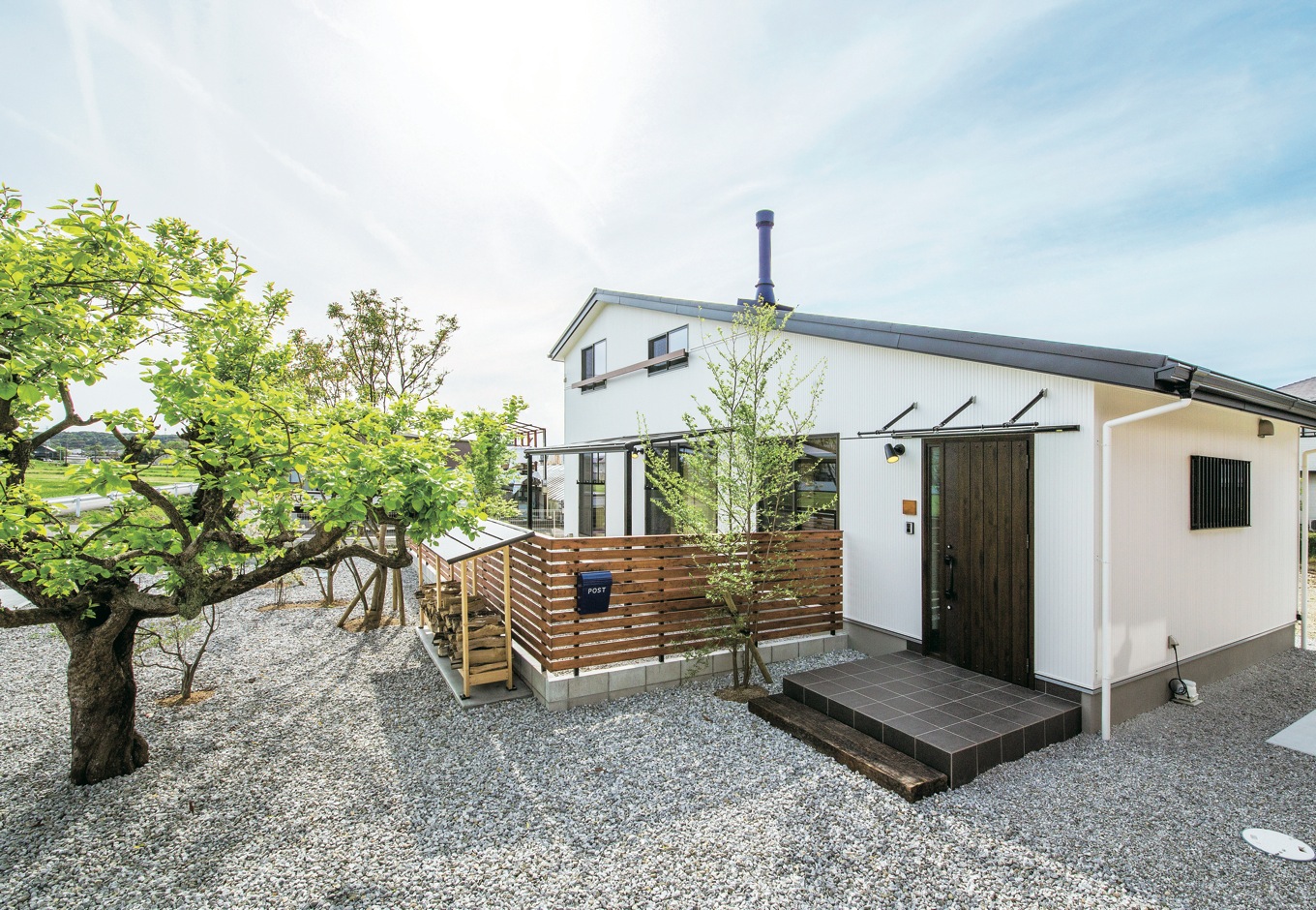 住たくeco工房【収納力、自然素材、間取り】外からは2階建てのようにも見える大屋根の外観。シンボルツリーの柿の木はご主人が生まれる前から暮らしをずっと見守り続けてきた