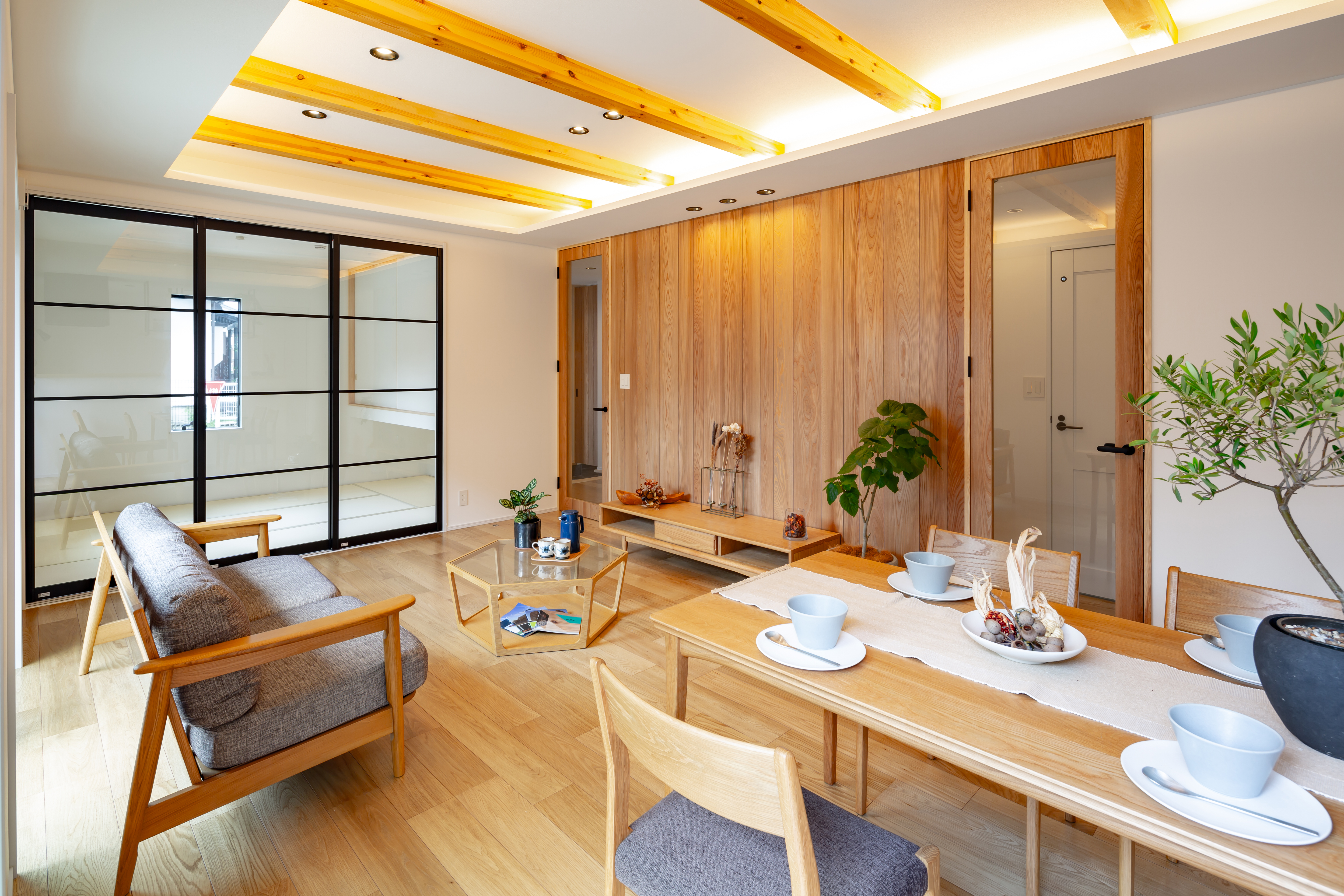 ムニカデザイン（まほろばホーム）｜和室とリビングの間を、開閉できる引き戸で仕切ることで、必要に応じて空間を広げたり、プライベートな空間を確保したりできる設計に。開け放てば一体感のある広々とした空間に、閉じれば静けさのある独立した和の空間へ