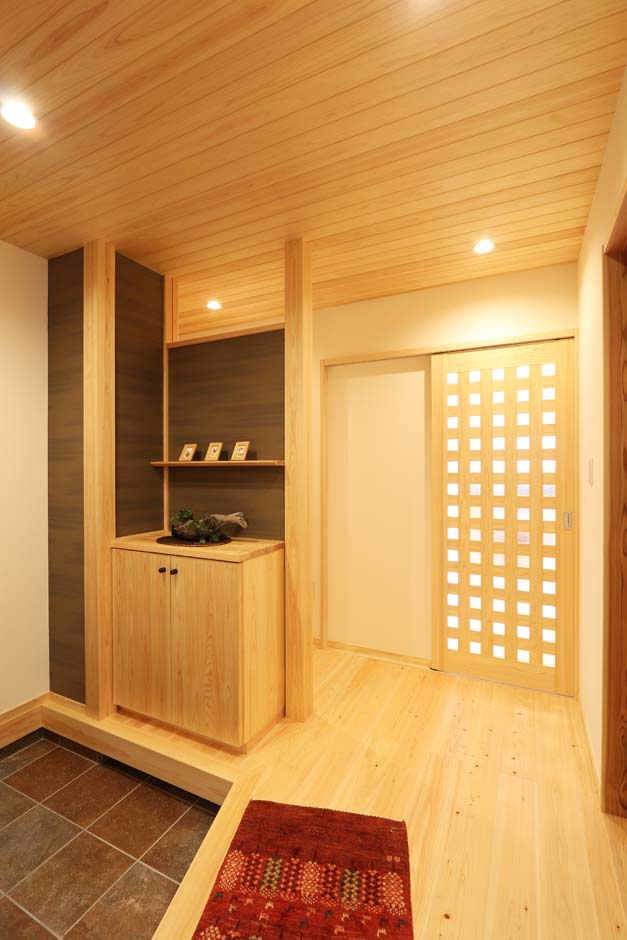 エコフィールド【自然素材、省エネ、間取り】天井に使用した檜羽目板が光を柔らかく広げ、玄関を優しく穏やかな雰囲気に