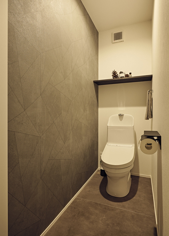 床のタイルと壁をグレーでまとめたトイレ