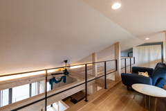 天井が低くコンパクトにまとまったくつろぎのロフトスペース。リラックスできるように配置されたソファが特徴的である。