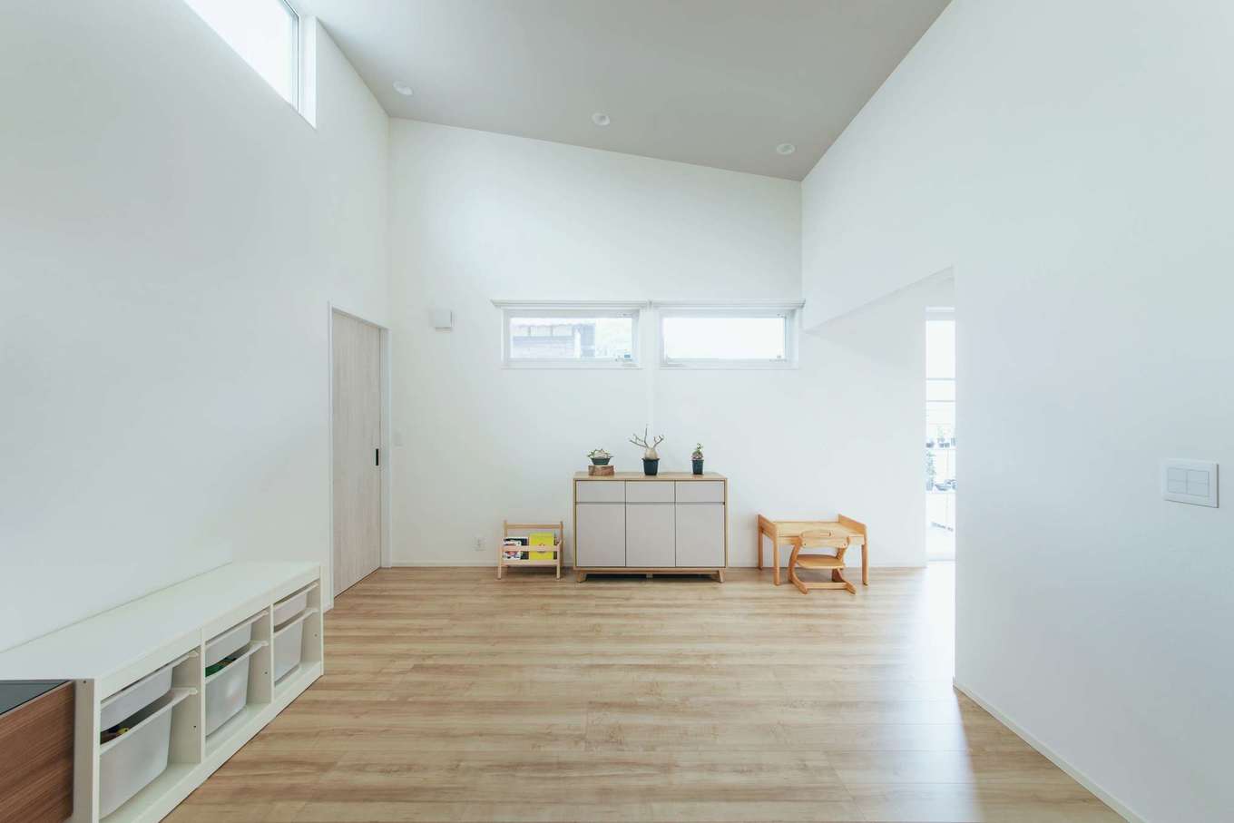 子育て安心住宅 Design Craft Office【デザイン住宅、趣味、平屋】勾配天井によって開放感が倍増したリビング。高窓から明るさも十分に確保した。子どもがのびのび遊べるように当分はソファを置かない予定。植物の作業スペースともつながり、移動もスムーズだ