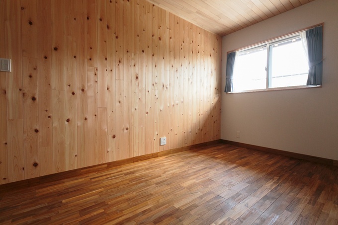 木の温もりが感じられる子ども部屋。窓から柔らかな光が差し込み、自然を感じる落ち着いた空間。