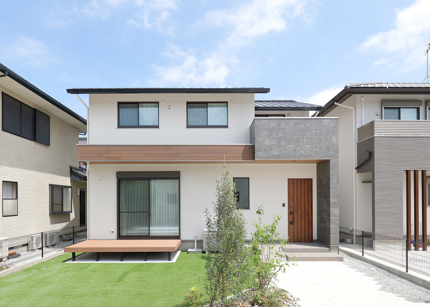 丸昇彦坂建設【デザイン住宅、和風、間取り】白で統一した外観が緑の芝生に映える。庭にはウッドデッキがあり、のびのびとくつろぐことができる。広々とした２階のバルコニーでは、布団を干したり、アウトドア気分を楽しんだりすることができる