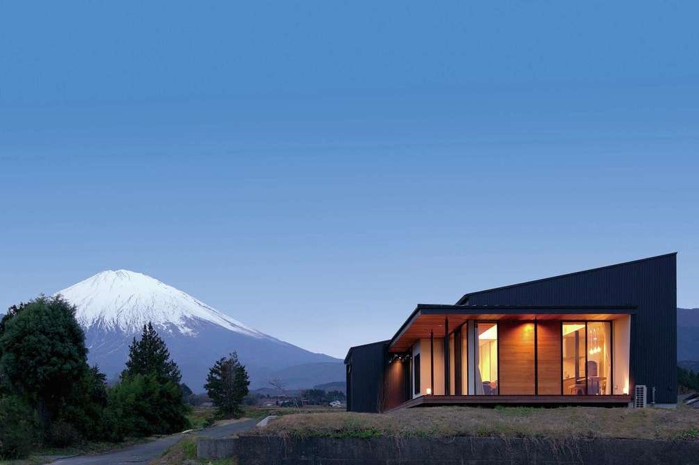 TENアーキテクツ 一級建築士事務所【デザイン住宅、建築家、平屋】富士山を間近に望むことができる好ロケーションに建つ。外観はグレーのガルバリウム鋼板に、重厚でモダンなチークの板張りがアクセント。勾配天井部分がロフトになっている