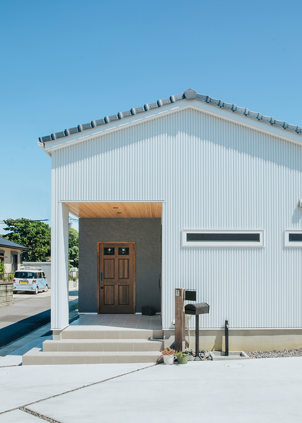 ナイスホーム【デザイン住宅、間取り、平屋】瓦の屋根に白いガルバリウム鋼板を組み合わせた爽やかな印象の外観デザイン。塩害・海風対策として、耐風タイプの瓦、サビに強いSGL鋼板の外壁、樹脂サッシ、耐風シャッターを採用した