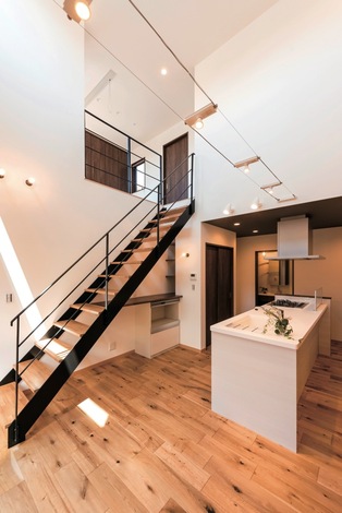 ダイニングは開放的な吹き抜け。ワイヤーで渡すタイプのダウンライトも、空間をお洒落に演出している