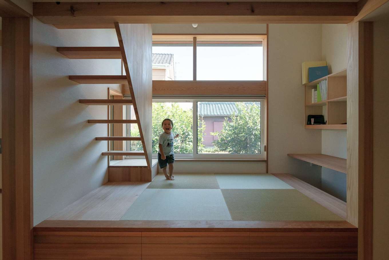 石牧建築【自然素材、間取り、平屋】”2両目”は小上がりで畳敷のファミリースペース。ロフトへ上がる階段は杉の赤柾パネルを使用。掘りごたつのカウンターは夫婦のワークスペースで、将来的に子どものスタディコーナーとしても活用できる