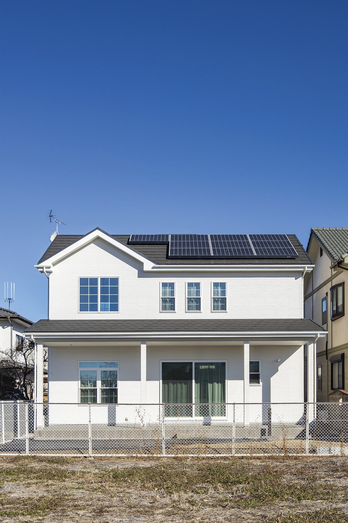 アヴィエスホーム｜太陽光パネルが設置されたエコな住宅。採光性と通風性が高い大きな窓が特徴で、快適な住まいを提供する。