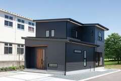 外壁はご主人の希望を取り入れて黒一色で統一。木質の玄関ドアをアクセントにしている
