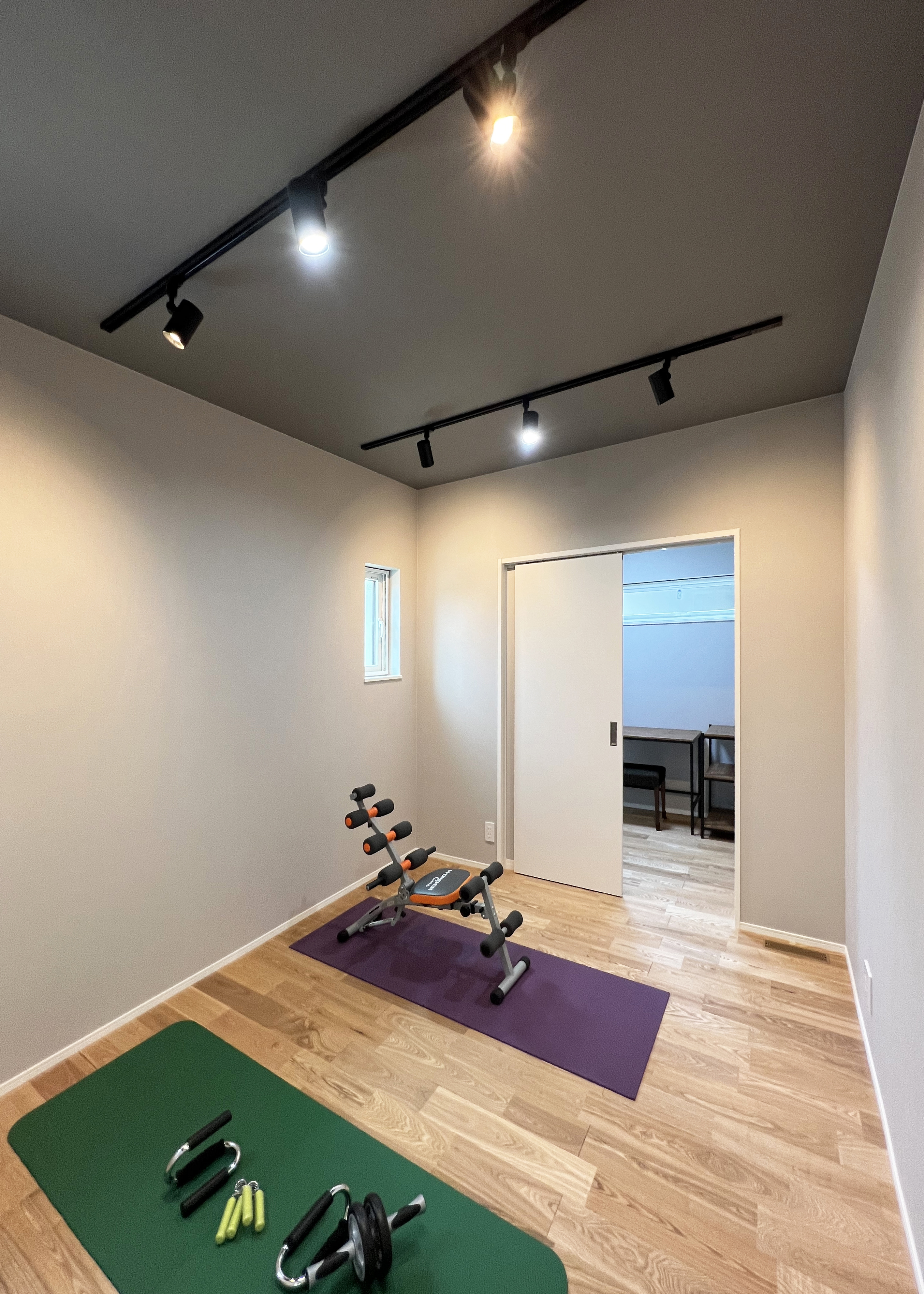 ユートピア建設【省エネ、間取り、平屋】5.3畳のトレーニングルーム。床は構造用合板で補強し、天井は可能な限り高さを確保した。奥には2.5畳の書斎が設けられている