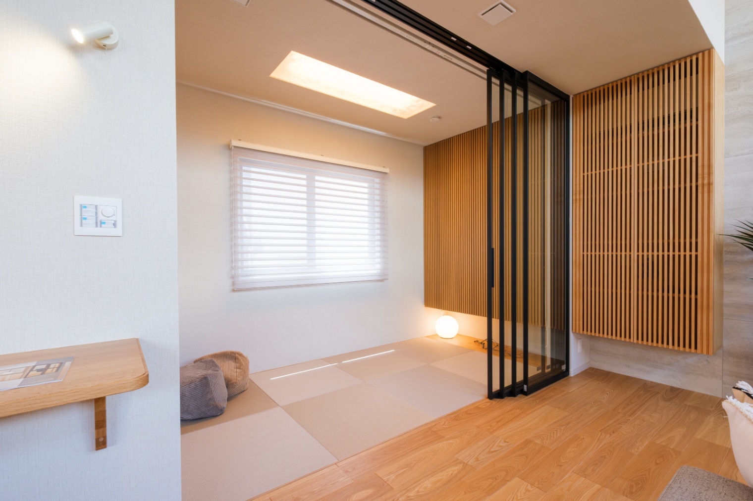 新栄建設｜明るいナチュラルデザインの畳スペース。普段は開けっ放しでリビングと一続きに、扉を閉めれば独立した部屋としても使える。造作の格子扉の収納にはエアコンが隠れている。