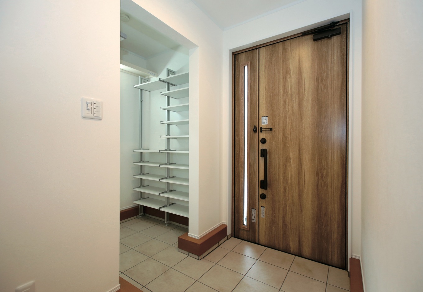 片桐建設【デザイン住宅、輸入住宅、省エネ】玄関ホールも広々。シューズクロークだけで1.6畳ほどあり、家族4人の靴や趣味のものがすっきり収まる広さ。上がりかまちは、木目が美しい