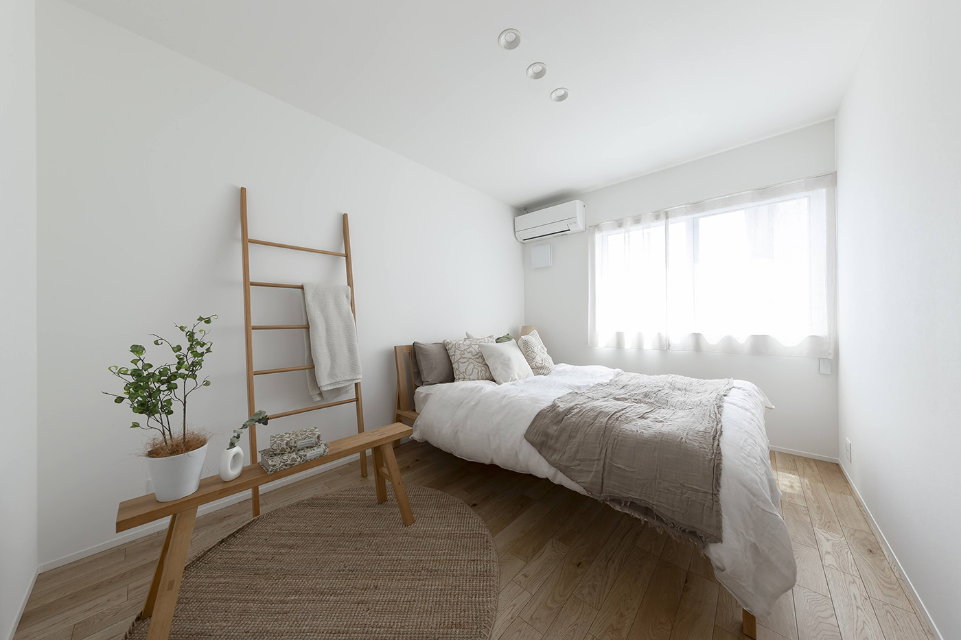 PG HOUSE（ピージーハウス）【浜松市中央区曳馬6-19-5・モデルハウス】東側の窓から朝日が注ぎ、爽やかな目覚めを迎えられる主寝室。ベッドの両側にはサイドテーブルを置けるスペースを確保。ファミリークローゼットがすぐ近くに設けてあるため大型の収納家具を置かずに済み、すっきりとした空間を保てる