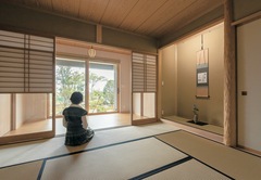 二世帯を家の中でつなぐ渡り廊下スペースに、茶室兼仏間の和室を配することで、お母さまの生活空間としても使用可。親子世帯を緩くつなぐ共有スペースとなっている