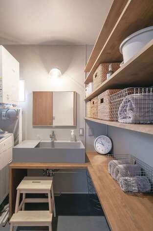 自宅の洗面スペースはシンクや腰壁をグレーで統一。収納棚もたっぷり設けてある