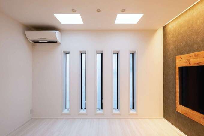 リビングはプライバシーに配慮してスリット窓に。しかし2つのトップライトのおかげで日中は電灯をつけなくても十分明るい