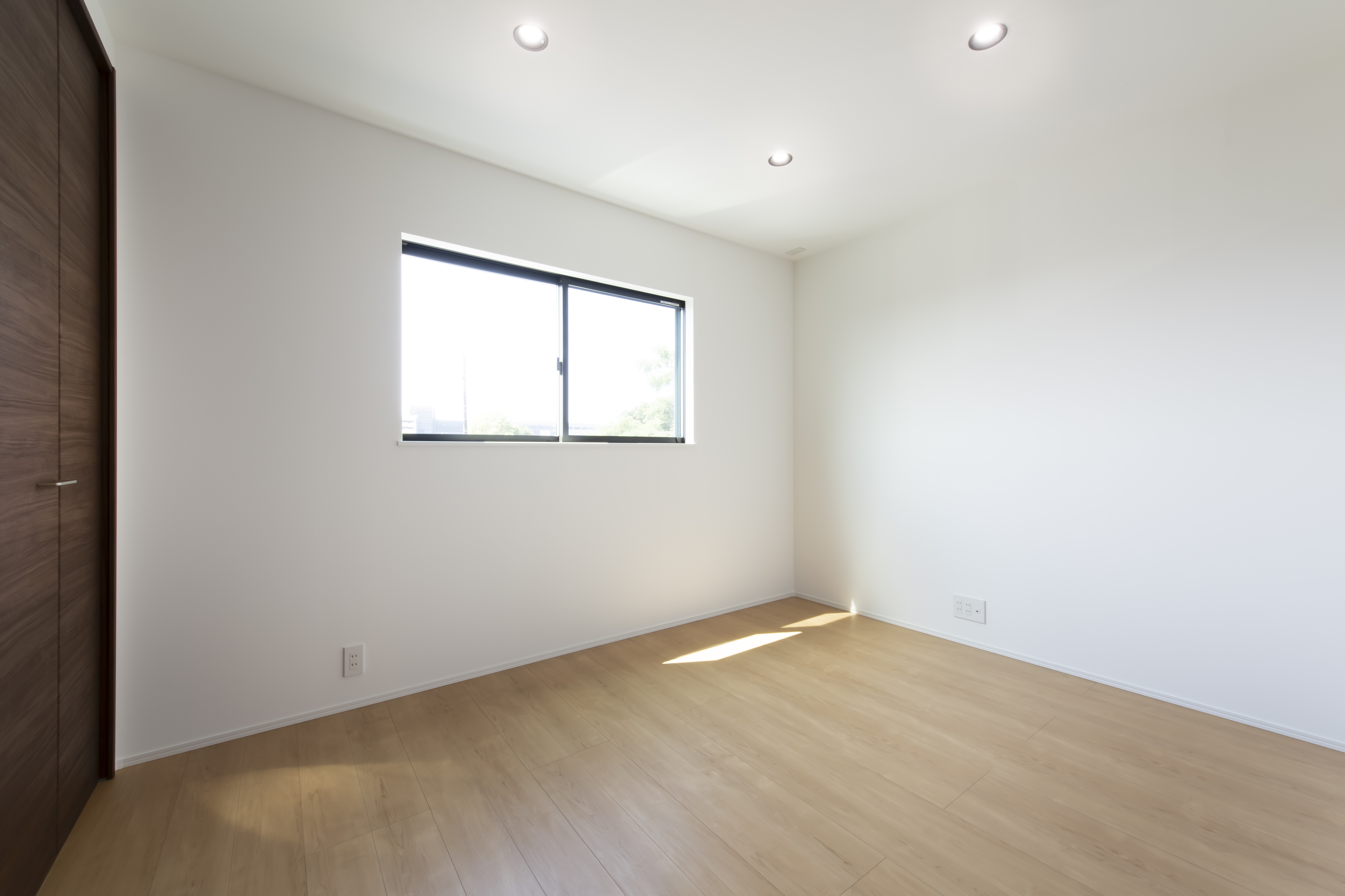 スズイチ｜広々とした明るい居室。ナチュラルな木の床が心地よく、シンプルなデザインが印象的である。