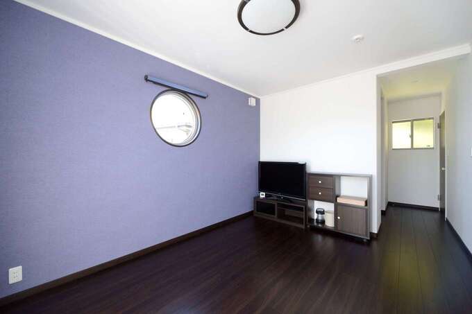 藤色のアクセントウォールが映える主寝室。床の色を濃くして、リラック効果を高める