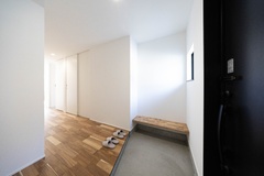 エントランスに設置した床と同じ材を使用したベンチ。ご家族の想い出を飾る事もできますし、靴の脱ぎ履きで荷物を置きたい時や、玄関先で立ち話の時にも活躍します。