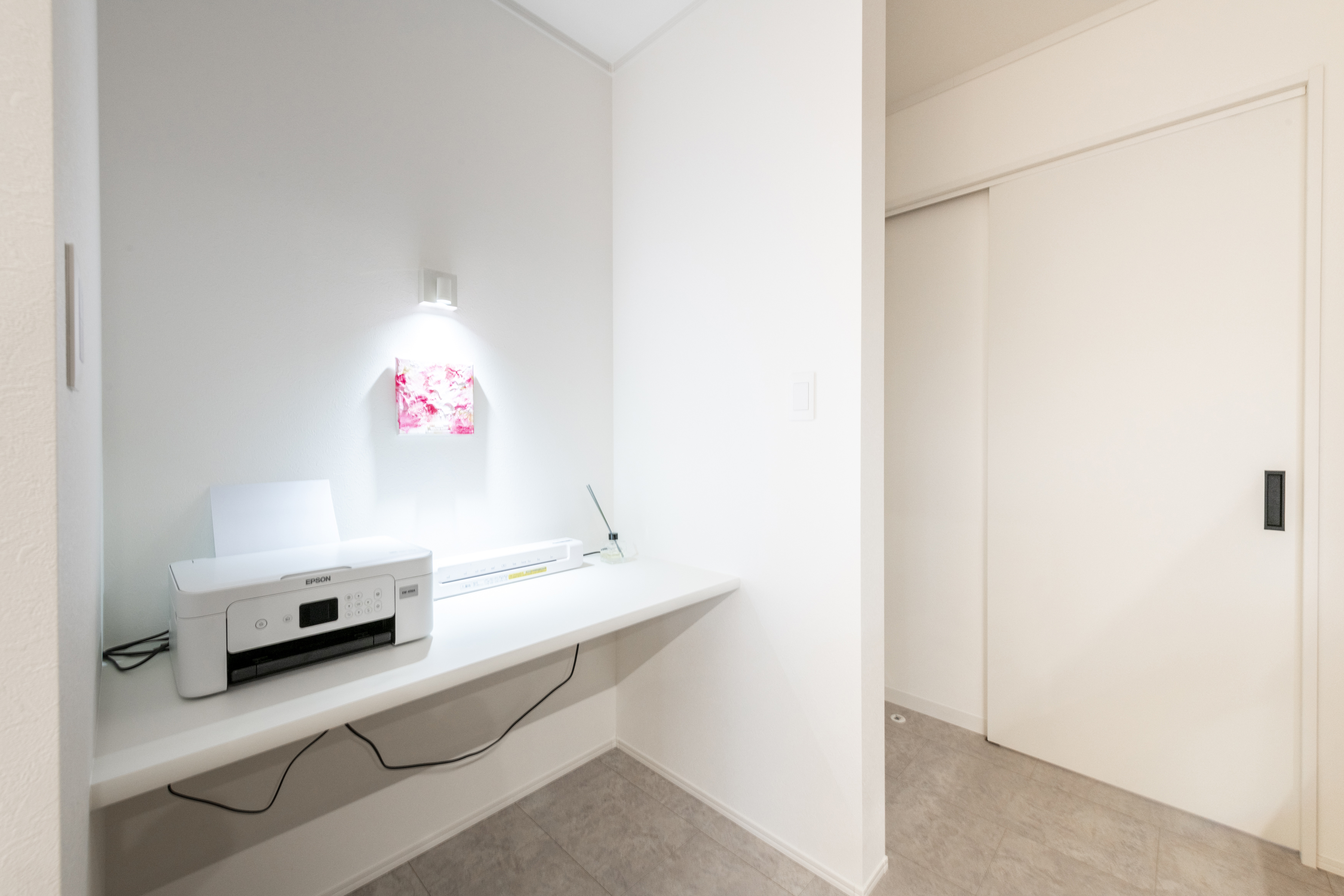 広島建設 セナリオハウス｜キッチンのすぐ目の前にあるワークスペース。壁に取り付けられたシンプルなデスクが特徴で、照明が手元を明るく照らし作業に集中できる環境が整っています。将来的には、お子様のスタディースペースに。