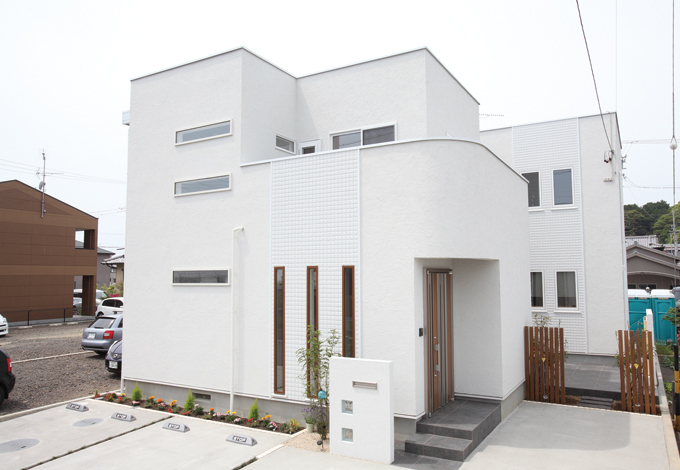 白い外観に縦横のラインが美しい。素材は塗り壁と防火性に強いALC( 軽量気泡コンクリート）を使用