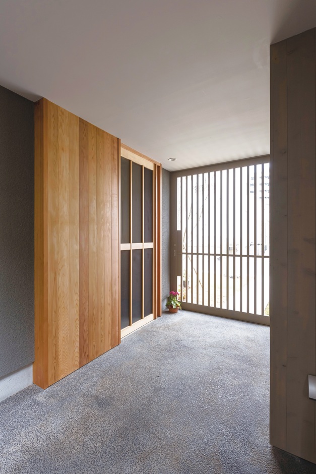 irohaco（アヴァンス）【デザイン住宅、子育て、間取り】アプローチから格子戸を開けて玄関ポーチへと入ってすぐのところに、外収納と駐輪場を設置。ガーデニング用品やアウトドアグッズなど、外で使うものを丸ごと全部収納できるので、玄関回りをスッキリと保てるところが気に入っています。(旦那さま)