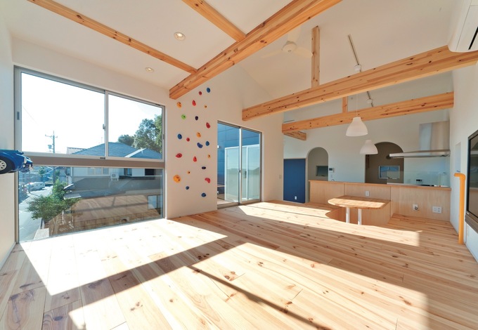 パイン材の風合いが心地よいシンプルなLDK。リビングは小上がりにして、部屋中をゴロゴロで きるようにした。対面キッチンの向かいには掘り座卓を配置