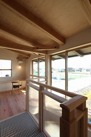 階段からサンルームへの通路は、床をグレーチングとし、１階の土間に光が届くよう配慮。サンルームは、Sさん・Nさん共用の書斎兼物干しスペース