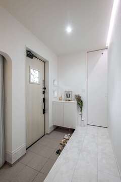 玄関は大理石調フローリングに。左手は機能的なシューズクローク