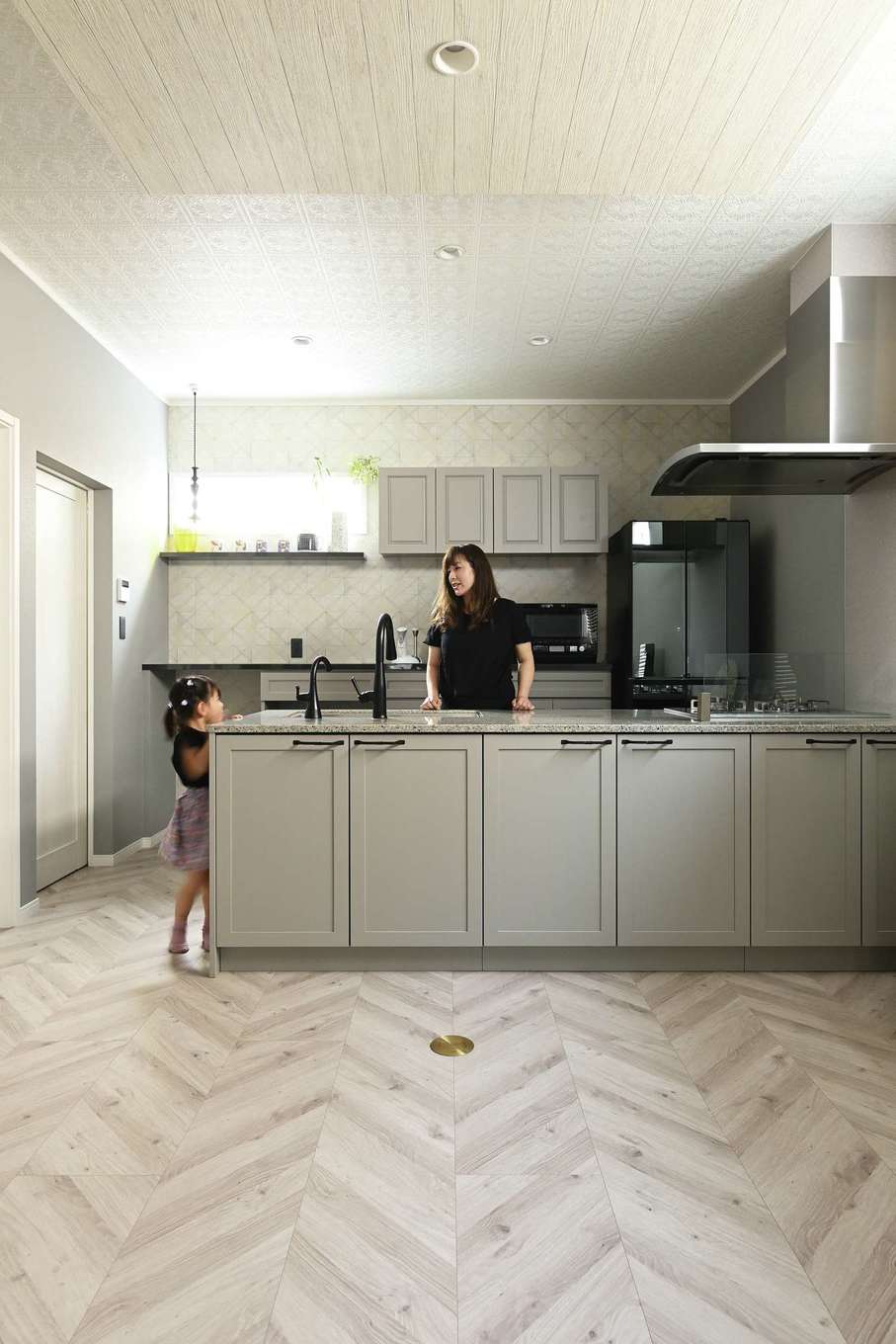 ハートホーム【デザイン住宅、子育て、輸入住宅】外国の映画やドラマに登場するような大理石のキッチン。同じデザインと色合いでコーディネートした背面の収納も造作。一部はスツールを置いてワークスペースとして活用できる